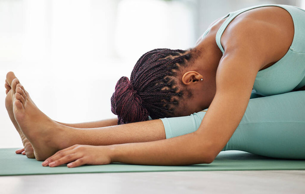 Estirar mis isquiotibiales. una mujer irreconocible practicando yoga sola y sosteniendo una pose sentada hacia delante - Foto, Imagen