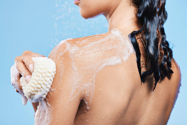 Girly and fragile, women are a thing of delicate beauty. an unrecognizable woman enjoying a soapy shower against a blue background - Фото, зображення