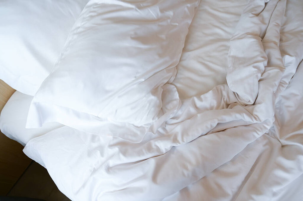 witte kussens op verfrommeld bed - Foto, afbeelding