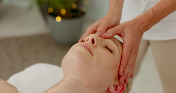 Spa, hands and head massage on bed for wellbeing lifestyle with professional masseuse service. Woman at salon resting with luxury massaging facial from therapist for forehead pressure relief - Metraje, vídeo