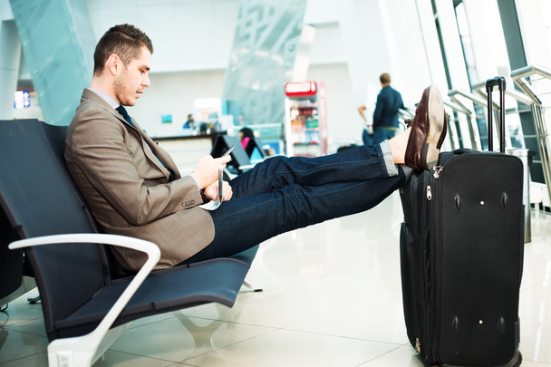Businessman at airport with smartphone - Zdjęcie, obraz