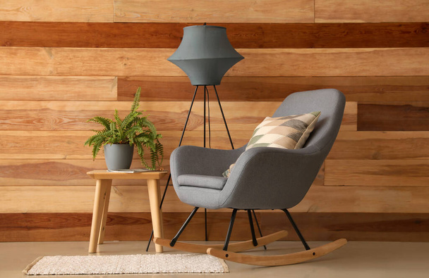 Belső tér hangulatos nappali szürke fotellel, asztal és lámpa - Fotó, kép