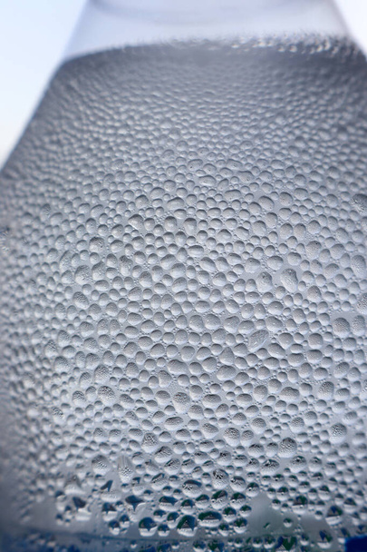 Superficie fría de la botella de agua con burbujas espumosas macro disparo - Foto, Imagen