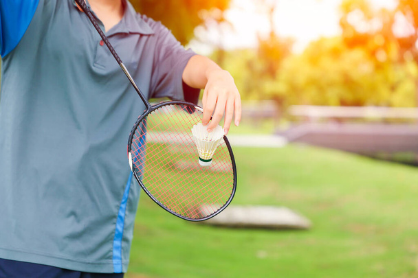 hand dienen badminton shuttlecock outdoor sport spelen ontspannen vakantie plezier activiteit concept - Foto, afbeelding