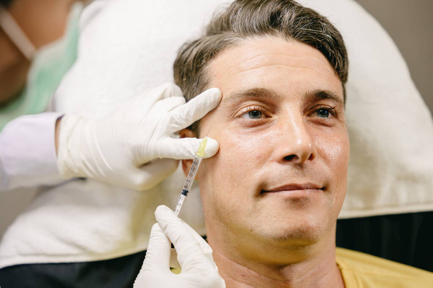 samec facelift kůže plnicí jehla injekce na obličej v kosmetické klinice - Fotografie, Obrázek