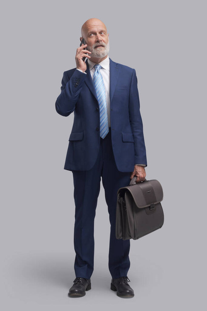 Корпоративному бизнесмену звонят со своего смартфона - Фото, изображение