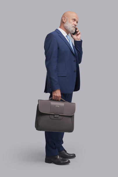Corporate businessman having a phone call with his smartphone - Zdjęcie, obraz