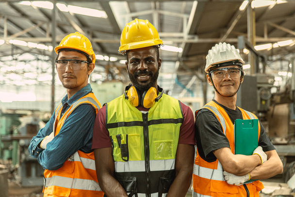 portrét tři muž inženýr dělnický tým stojí paže zkřížené sebevědomý šťastný úsměv. skupina průmyslových lidí mísí rasu. - Fotografie, Obrázek
