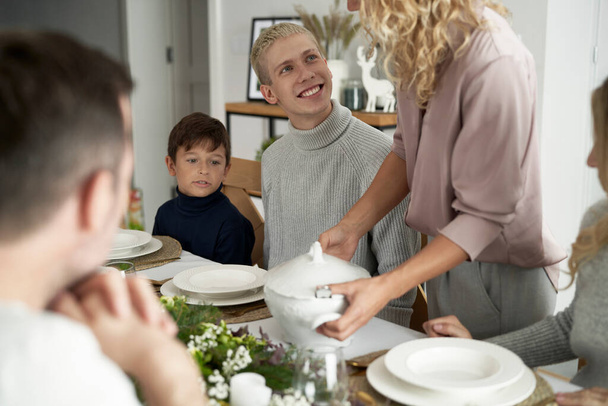 Valkoihoinen perhe tarjoilee perinteistä puolalaista keittoa jouluaattona    - Valokuva, kuva