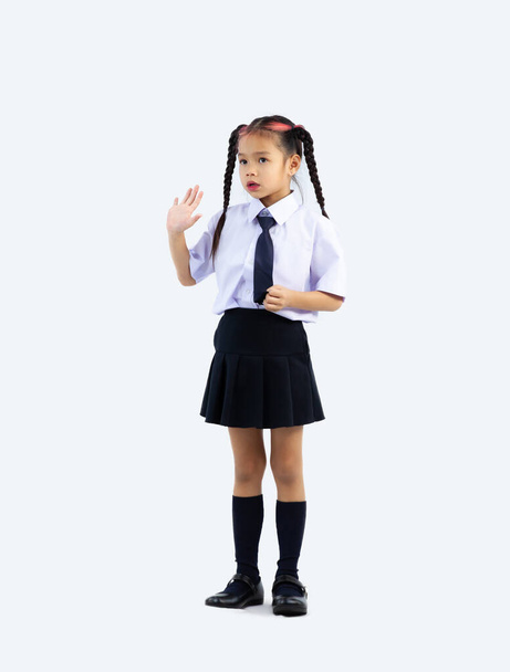 Asian junior school girl in student uniform standing full length white background. - Foto, afbeelding