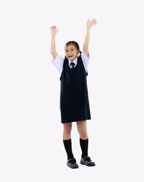 Back to school, junior schoolgirl in student uniform posing happy and hands up on white background.	 - Foto, Imagen
