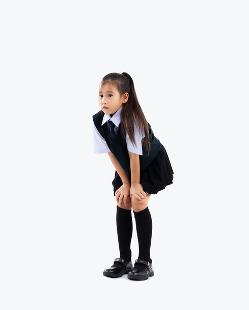 Back to school. Junior school international student in uniform posing hands on knee full length on white background. - Foto, afbeelding