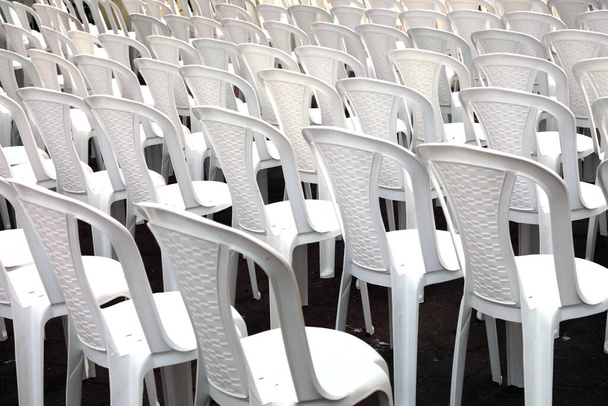 Reihen leerer weißer Stühle in einem Konferenzraum.  - Foto, Bild