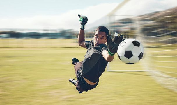 Voetbal, sport en keeper met een man die een schot, doelpunt of score opslaat tijdens een wedstrijd op een grasveld. Fitness, voetbal en training met een reu-sporter tijdens een trainingssessie. - Foto, afbeelding