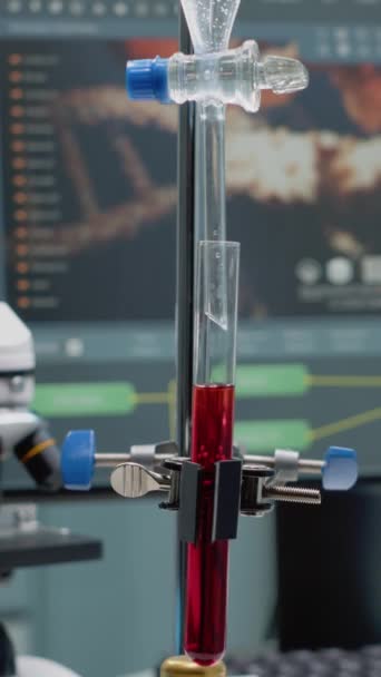 Vídeo vertical: Fechar o tubo de ensaio e o tubo para misturar soluções em laboratório na secretária. Equipamento de pesquisa médica em vidro usado em testes e experimentos de química com microscópio e computador - Filmagem, Vídeo