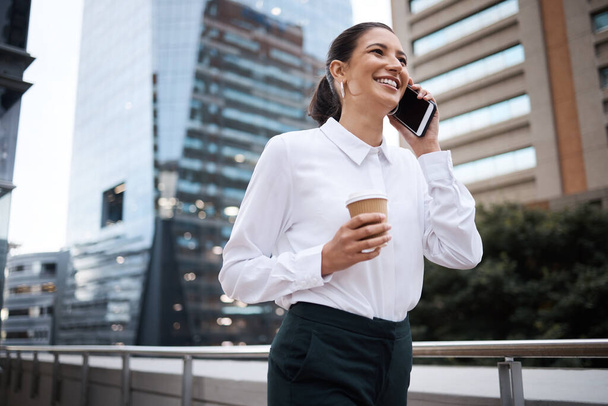 Her adımında kararlılığını taşıyor. Ofisin dışında kahve içerken cep telefonuyla konuşan genç bir iş kadını. - Fotoğraf, Görsel