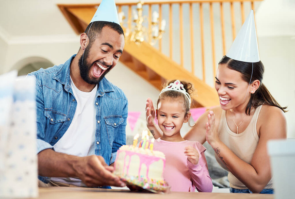 Un gâteau spécial pour une fille spéciale. une petite fille célébrant un anniversaire avec ses parents à la maison - Photo, image