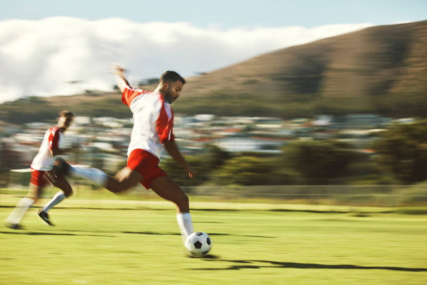 Energy, fitness and soccer training with soccer playing in power kick with ball on a soccer field for team sports game. Football, man and football player in competitive match, running and exercise. - Foto, Imagen