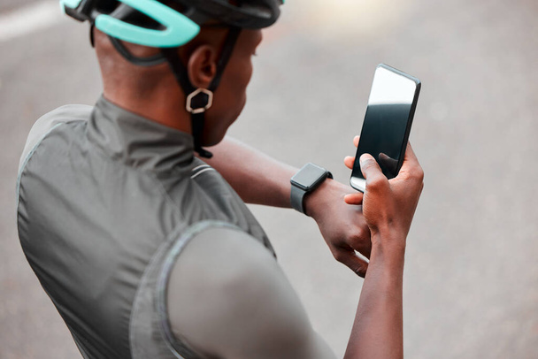 Cycling, smartwatch and phone by man cyclist tracking cardio, pulse and health on an online app in a road. Sports, fitness and watch with black man cycling and monitoring progress, heart and wellness. - Photo, Image
