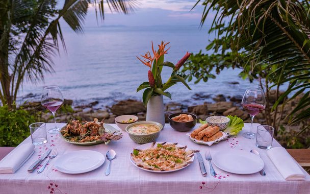 ruokapöytä katselee merelle thairuoan kanssa, illallinen auringonlaskun aikana. romanttinen illallinen - Valokuva, kuva