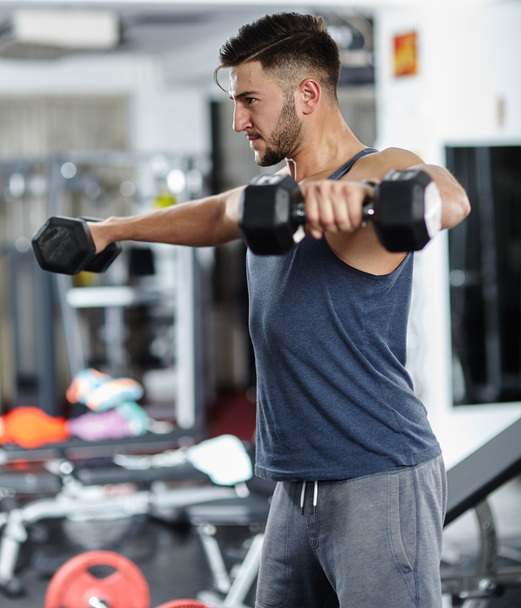 Man doing shoulder workout in a gym - Foto, Bild