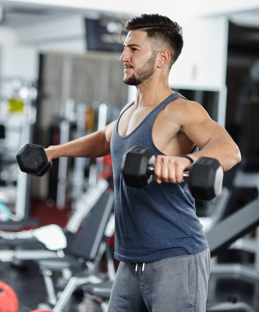 Man doing shoulder workout in a gym - Foto, Imagem