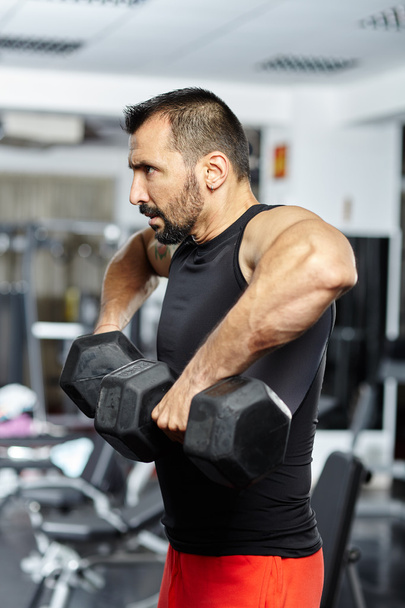 Man doing shoulder workout in a gym - Фото, изображение