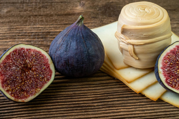 Figs, various cheese on a rustic table.Traditional hand made slovak smoked cheese parenica. Έννοια υγιεινής διατροφής. - Φωτογραφία, εικόνα