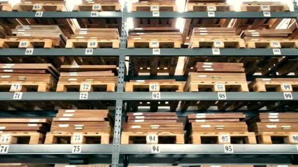 Lagerung von Waren in Holzregalen eines großen Lagerhauses. Lagerung von Kartons auf Holzpaletten. - Filmmaterial, Video