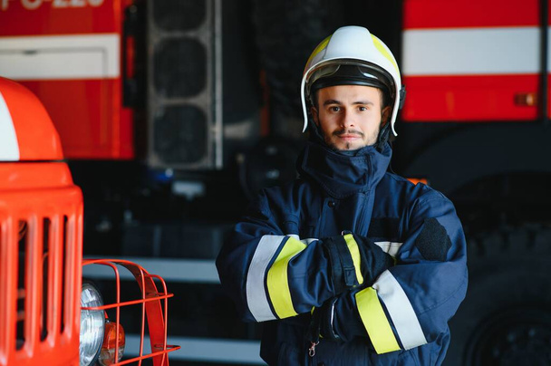 Fireman (firefighter) in action standing near a firetruck. Emergency safety. Protection, rescue from danger - Foto, immagini