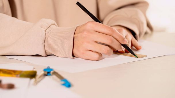 Cropped view of woman drawing with ruler on paper on table  - Photo, Image