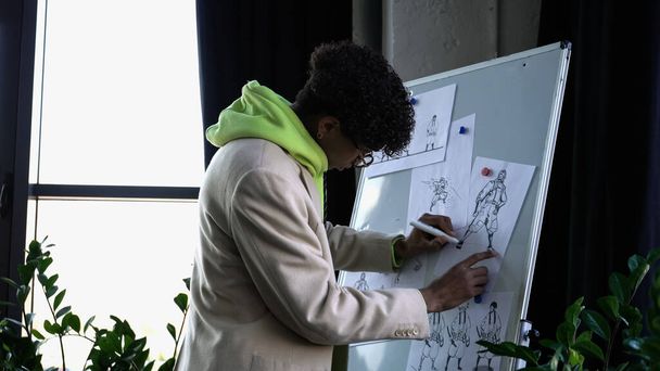 Elegante designer afro-americano desenhando esboços em estúdio  - Foto, Imagem