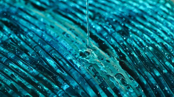 Close up view of blue hydrogel pouring on textured surface  - 写真・画像