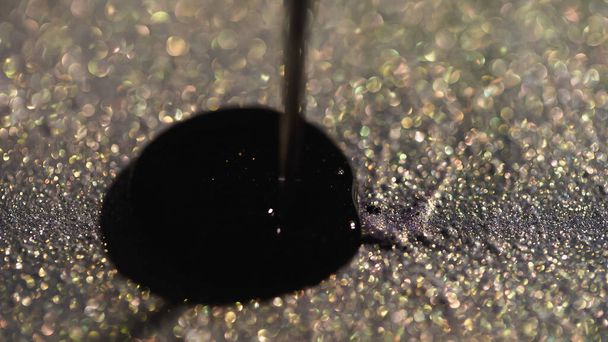Close up view of nail polish pouring on sparkling eye shadow  - Foto, Imagem