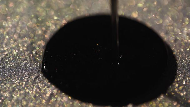 Κοντινή άποψη του μαύρου βερνικιού νυχιών στο αφρώδες glitter  - Φωτογραφία, εικόνα