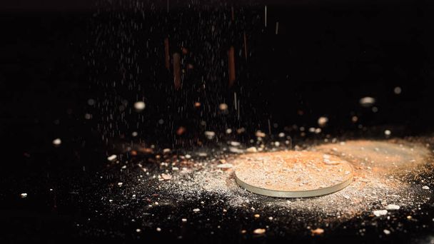 Close up view of blurred face powder pouring on black background  - Photo, Image