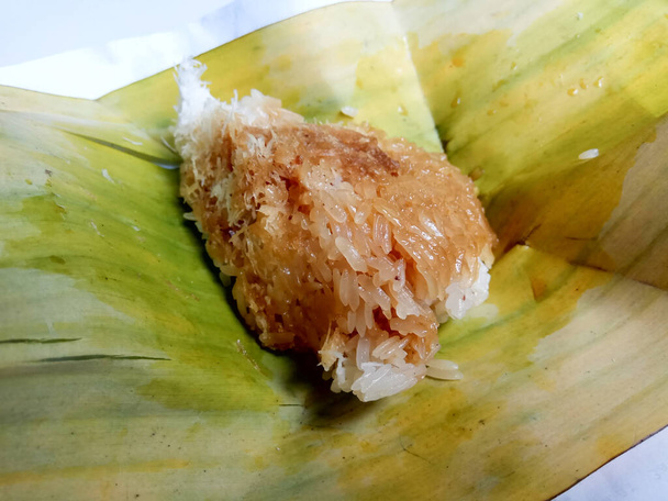 Ketan kincoa tai ketan kincaa. Javanese perinteinen välipala, valmistettu ahmatti riisi, raastettu kookos ja nestemäinen ruskea sokeri. Tarjoillaan banaaninlehtien pohjalla. Kulutetaan aamiaisena tai teevälipalana - Valokuva, kuva