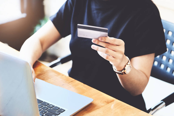 Online-Bezahlung mit jungen Frauen, die Kreditkarte in der Hand halten und Computer für Online-Einkäufe nutzen. - Foto, Bild