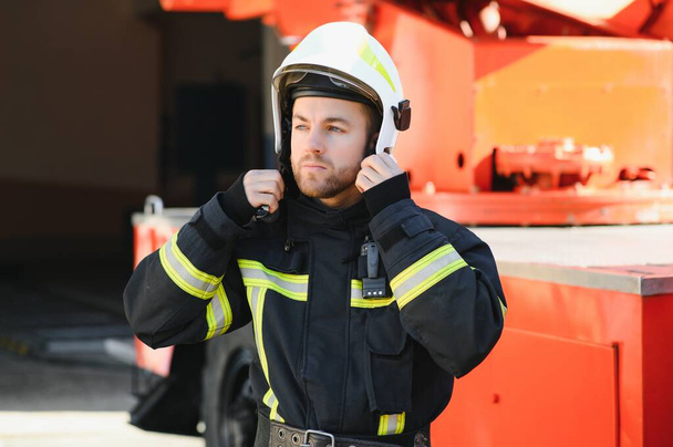 Firefighter portrait on duty. Photo fireman with gas mask and helmet near fire engine - Fotoğraf, Görsel