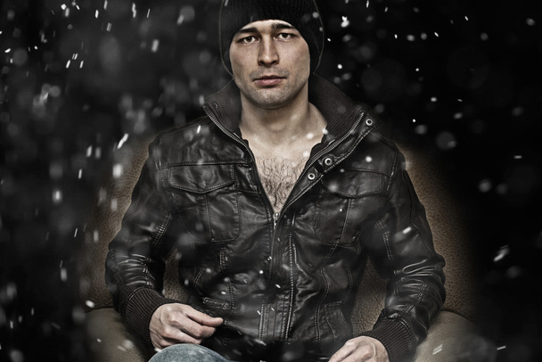 革のジャケット、カメラ目線で急な男。落ちてくる雪の結晶 - 写真・画像