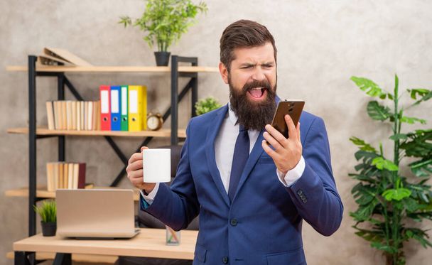 Stressed manager yelling in anger while talking on mobile phone in office, stress. - Foto, afbeelding