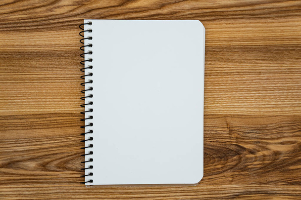 Cuaderno abierto en blanco con la página en blanco acostado en la mesa de madera. - Foto, Imagen