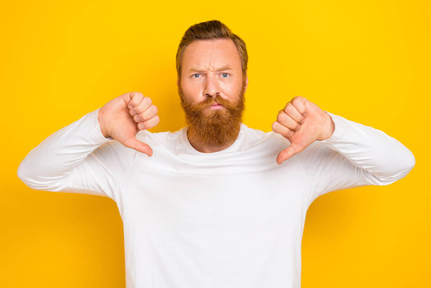 Photo of young unhappy funny guy red beard hair mustache angry depressed upset dislike thumbs down isolated on yellow color background. - Foto, immagini