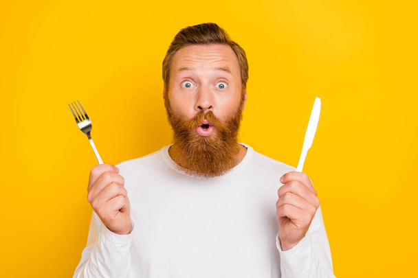 Photo portrait of handsome young man hold cutlery impressed new healthy diet wear stylish white garment isolated on yellow color background. - Фото, изображение