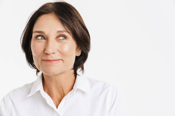 Mature brunette woman smiling and looking aside isolated over white background - Φωτογραφία, εικόνα
