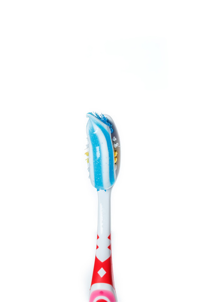 cepillo de dientes con pasta de dientes azul de dos colores en la superficie ligera
 - Foto, Imagen