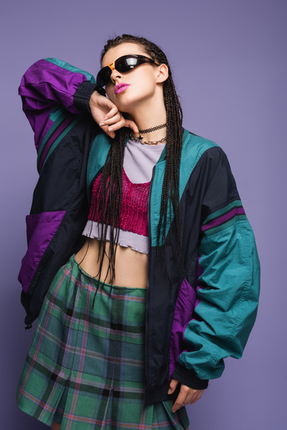 Trendy woman in vintage plaid skirt and sports jacket isolated on purple  - Fotografie, Obrázek