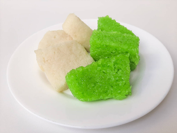 Jadah ketan (bianco) e wajik ketan (verde), due snack tradizionali dall'Indonesia. Fatto di riso appiccicoso. Su una lastra bianca, isolata su sfondo bianco - Foto, immagini