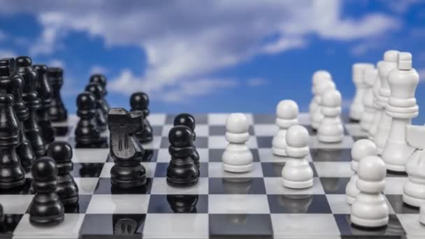 Ένα παιχνίδι σκάκι που παίζεται σε στάση κίνησης με περαστικά σύννεφα πίσω - Πλάνα, βίντεο