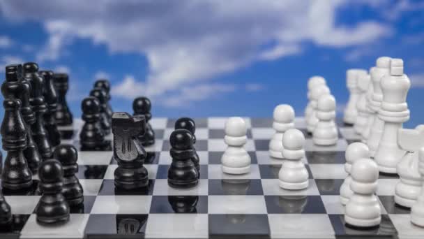 Ένα παιχνίδι σκάκι που παίζεται σε στάση κίνησης με περαστικά σύννεφα πίσω - Πλάνα, βίντεο